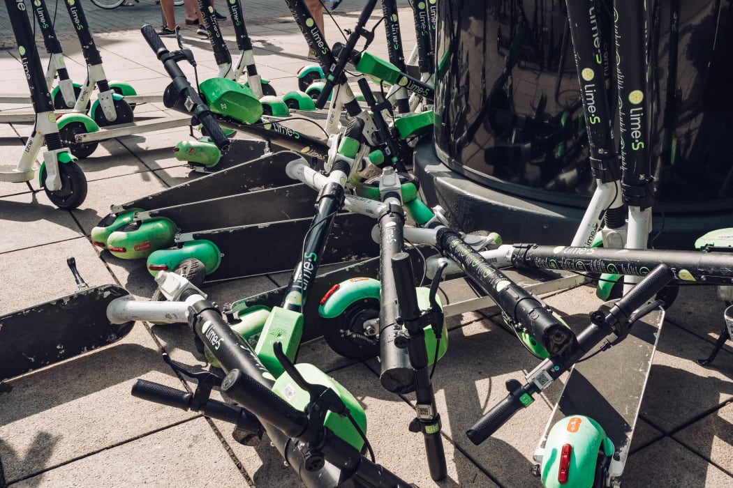 Lime e-scooters dumped on a pavement.