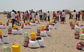 Yemenis displaced by the conflict, receive food aid and supplies to meet their basic needs, at a camp in Hays district in the war-ravaged western province of Hodeida on March 29, 2022.