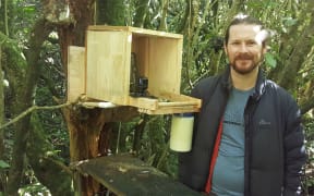 Daniel Donoghue next to his 'drop-in' kaka feeding station at Zealandia.