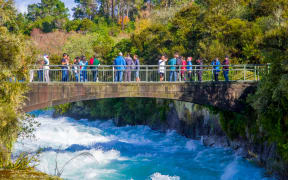 A crowd of people enjoying the view of Huka Falls on the Waikato River near Taupō.