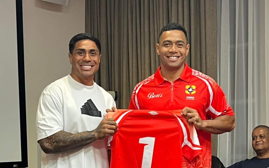 Malakai Fekitoa handing Tonga 7s captain Sione Tupou in Capetown.