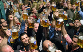 Stewards raise beer glasses in the Hofbraeu tent during the finale of the 183rd Oktoberfest in Munich, Germany, 3 October 2016
