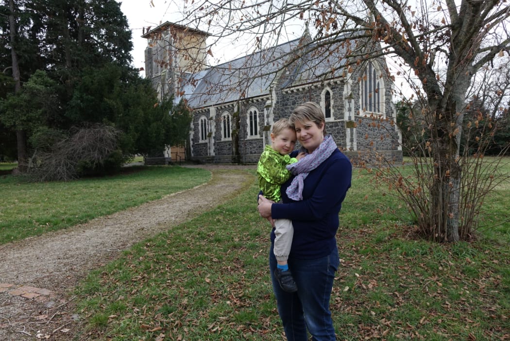 Cindy Driscoll and four-year-old Toby in from of the damaged St John's Church in Hororata.