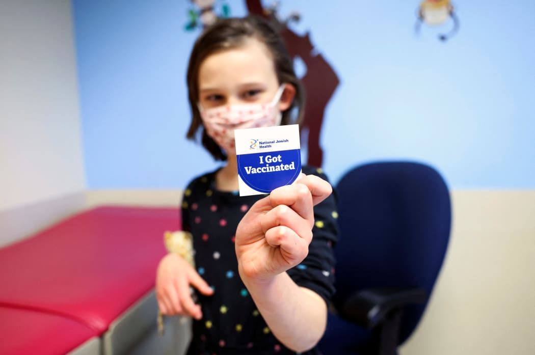 DENVER, CO - NOVEMBER 03: Margaret Sponsler, 7, holds out a sticker after receiving a dose of the pediatric COVID-19 vaccine at National Jewish Health on November 3, 2021 in Denver, Colorado.