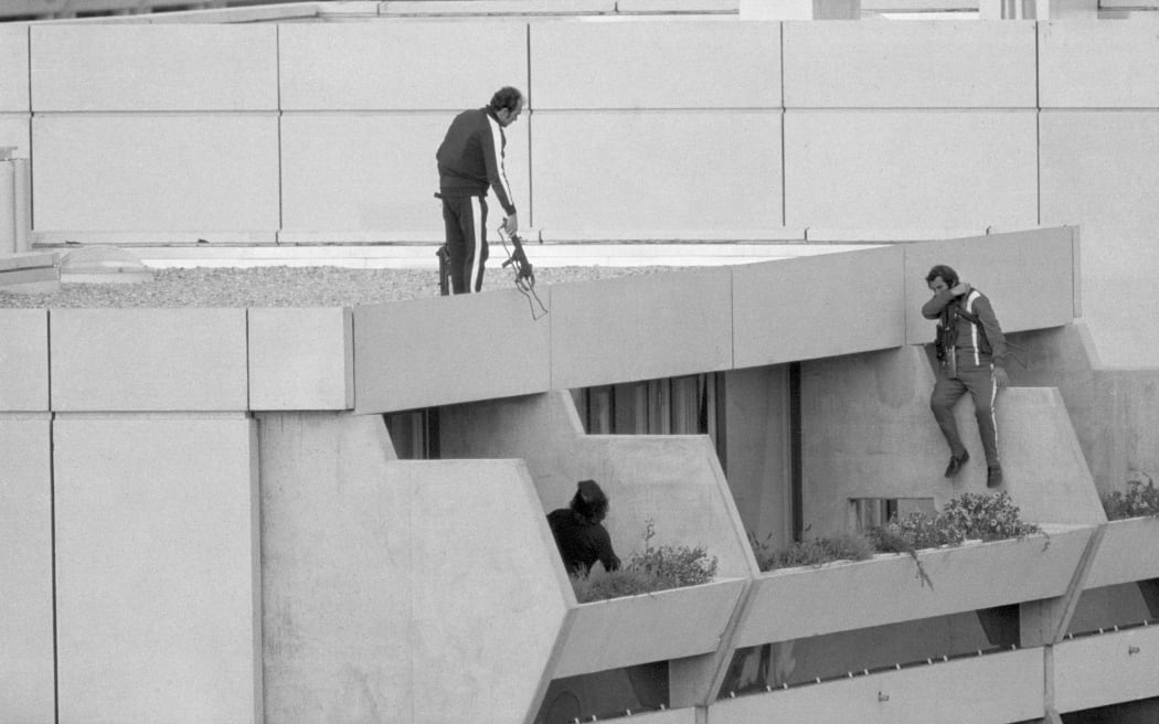 Armed police drop into position on a terrace directly above the apartments where between nine and 26 members of the Israeli Olympic team are being held hostage 9/5 by Arab "Black September" extremists.