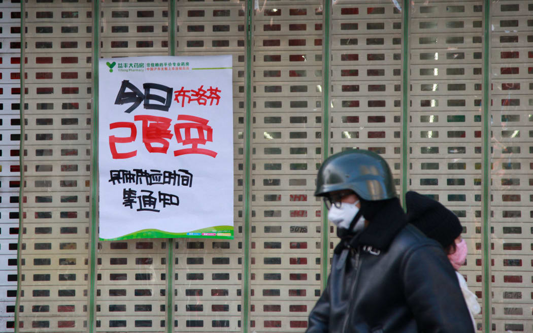 A man walks past a poster saying ibuprofen sold out today at a pharmacy amid the Covid-19 pandemic in Nanjing, in China's eastern Jiangsu province on 20 December.