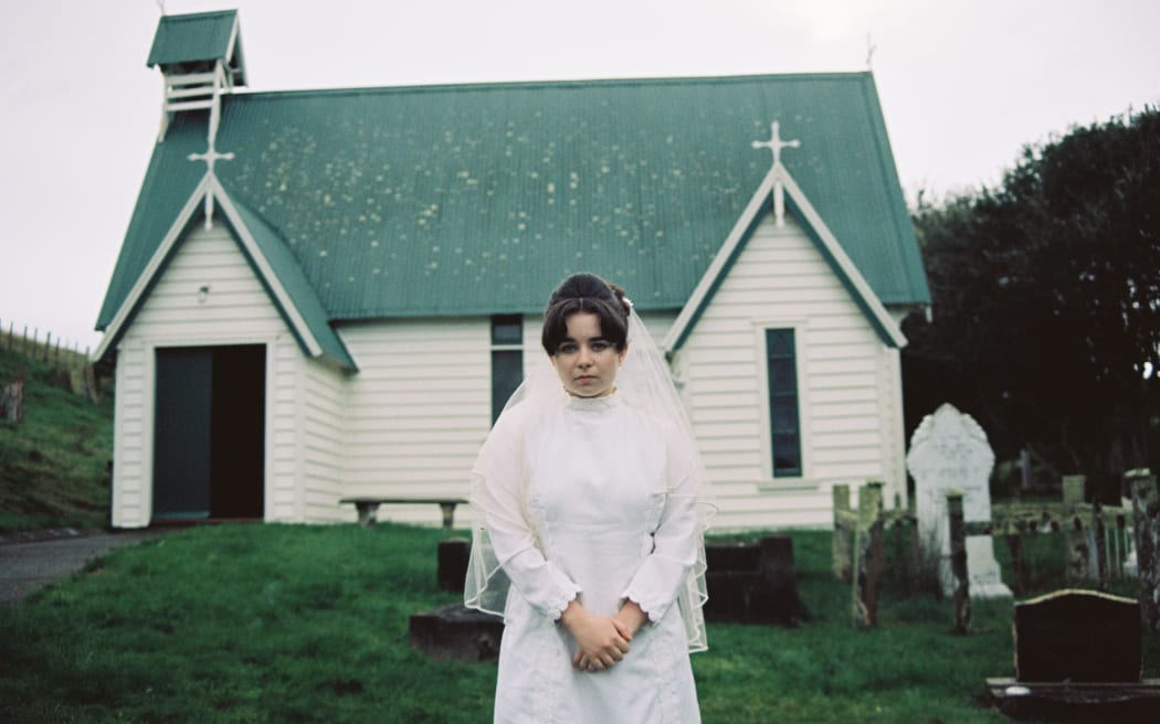 Mary (Maya Le Roux) stands outside the church on her wedding day.