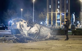 A burned car in front of Eindhoven central train station after the anti-lockdown protest.