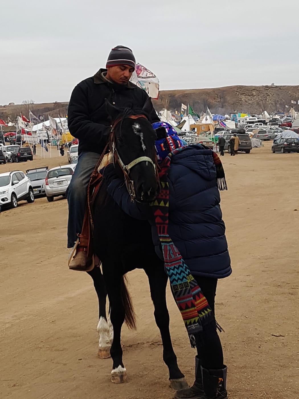 Honey Whakatope says a prayer with spirit horse rider at Standing Rock.