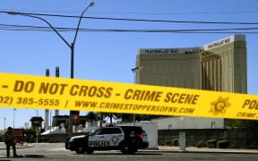 Crime scene tape surrounds the Mandalay Hotel with shooter's window damage in top right.