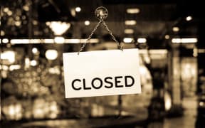 A closed sign hanging in a shop window