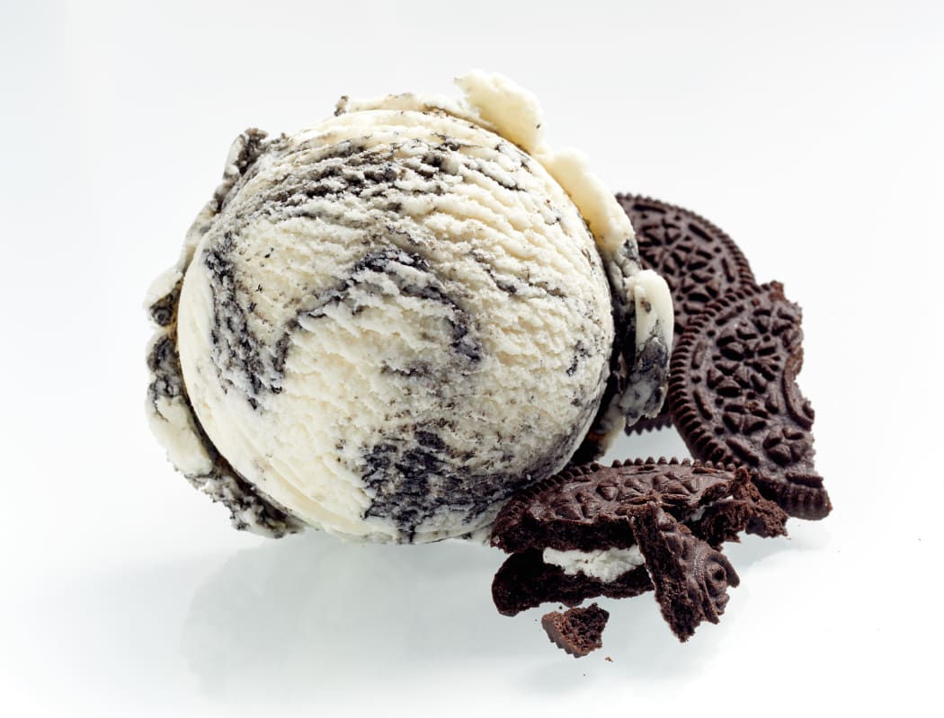 Speciality American oreo ice cream with crushed cookies alongside as ingredients isolated on white showing the texture of the scoop