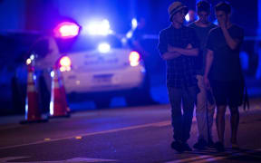 People walk by a police roadblock near the Pulse nightclub.