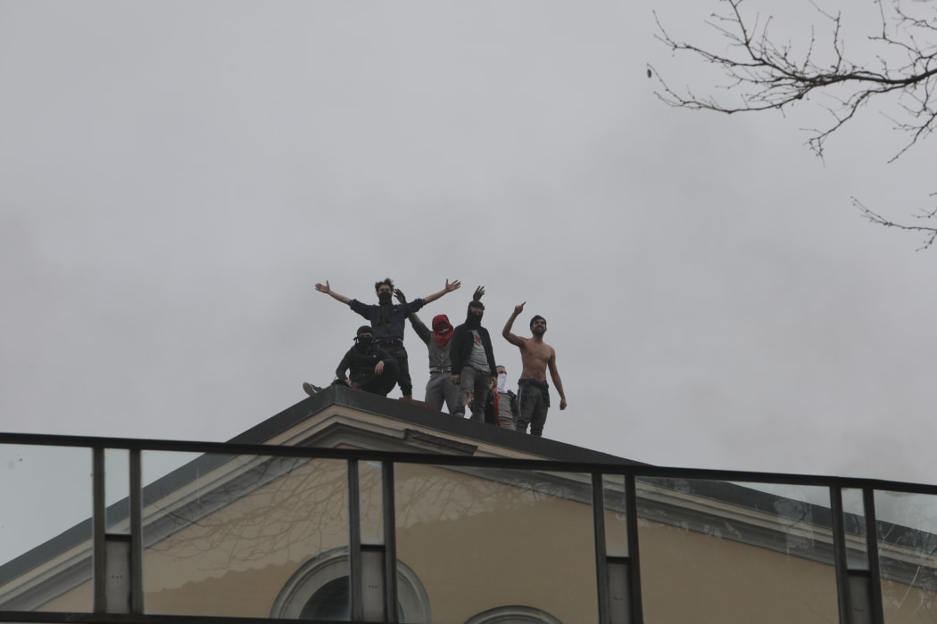 Inmates stage a protest on a rooftop of a wing at the San Vittore prison in Milan on 9 March.