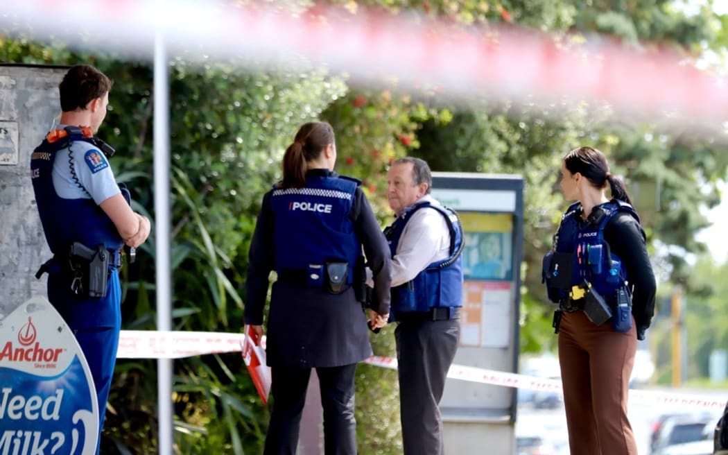 Police officers outside the New Windsor Dairy in Auckland after an assault there that left two people in hospital.