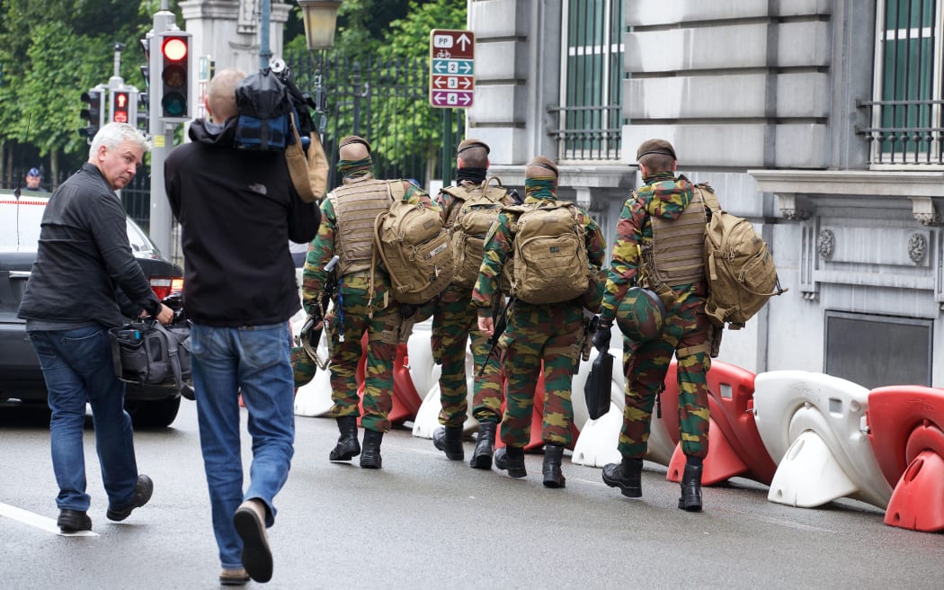 Soldiers pictured outside a meeting of the security council after the dismantling of a new terrorist unit last night in Brussels.