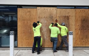 MIAMI BEACH, FLORIDA - AUGUST 30: Workers place plywood over windows as they prepare a business for the possible arrival of Hurricane Dorian on August 30, 2019 in Miami Beach, Florida.