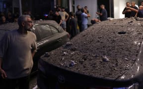 Debris covers a damaged vehicle following an Israeli military strike on Beirut's southern suburbs on July 30, 2024. The Israeli military said it carried out a strike on July 30, in Beirut that targeted a Hezbollah commander responsible for the killing of children in last week's rocket attack on the Golan Heights. A source close to Hezbollah told AFP that a senior commander was targeted in an Israeli strike on its south Beirut stronghold. (Photo by ANWAR AMRO / AFP)