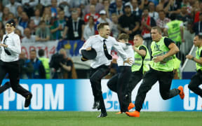 Stewards remove pitch invaders during the Russia 2018 World Cup final football match between France and Croatia at the Luzhniki Stadium in Moscow on July 15, 2018.