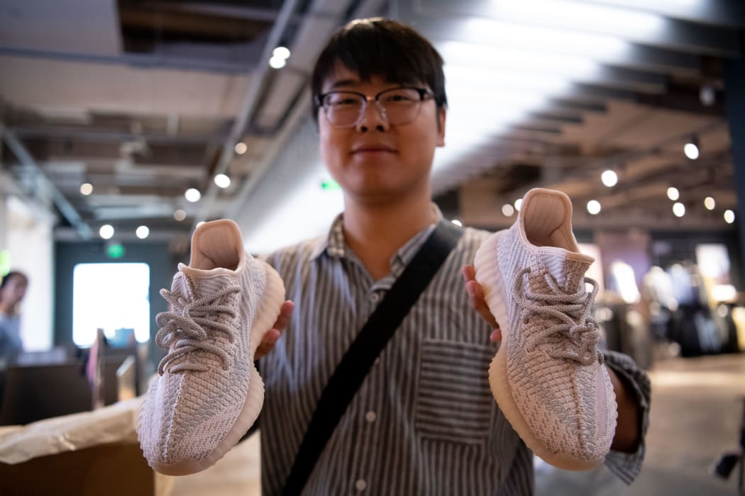Man holds Adidas Yeezy, a collaboration between German sportswear brand Adidas and Kanye West.