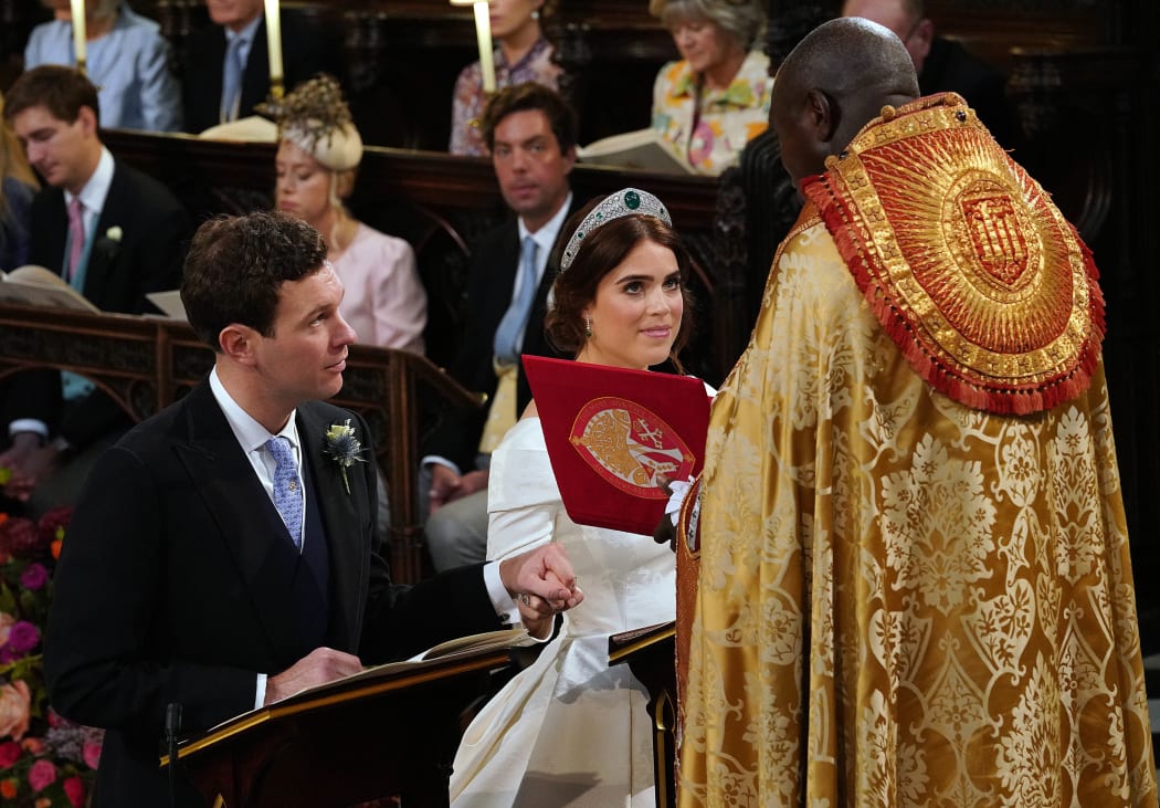Britain's Princess Eugenie of York and Jack Brooksbank kneel at the altar during their wedding ceremony at St George's Chapel, Windsor Castle.