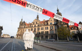 Two police forensic team members stand in front of the Residence Palace with the Green Vault behind a barrier tape. Dresden's Treasury Green Vault was broken into early in the morning.