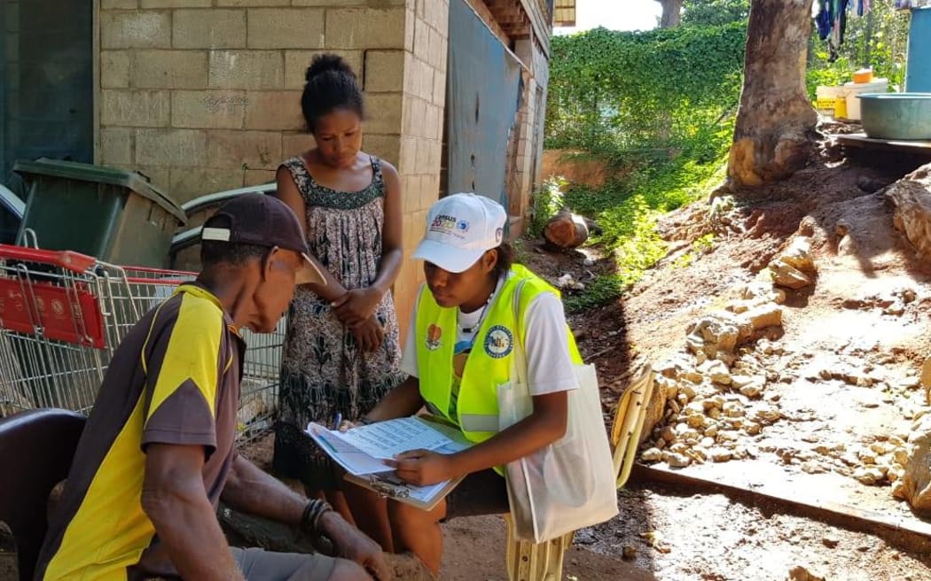 A Papua New Guinea census official helping people fill out census forms for the 2021 census, in 2020.