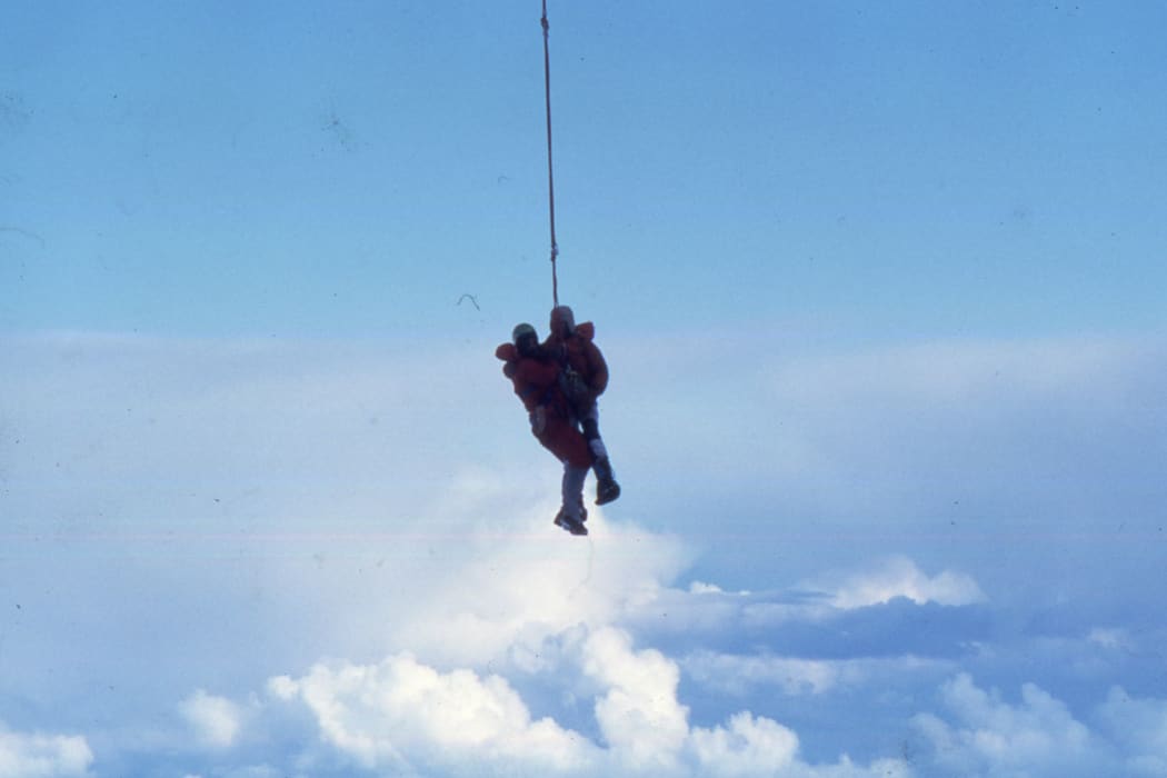 A photo of Don Bogie handing from the helicopter with Phil Doole attached to him after rescuing him from the ice cave known as 'Middle Peak Hotel'