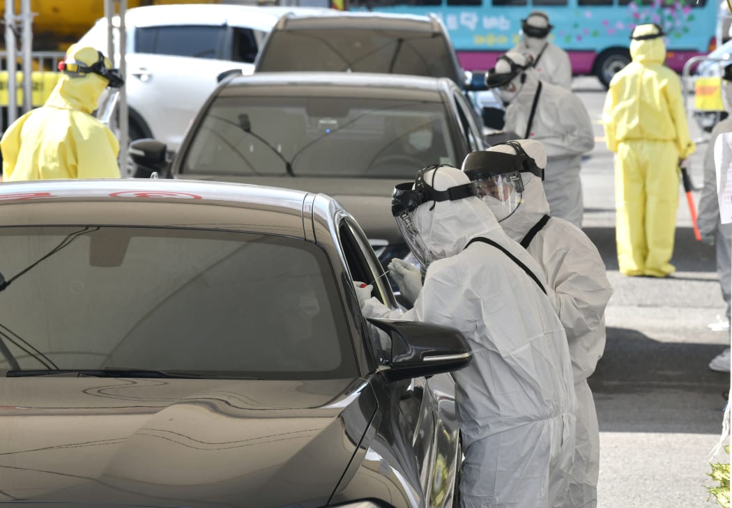 Medical staff wearing protective gear at a "drive-through" virus test facility in Goyang, north of Seoul, 29 February 2020.