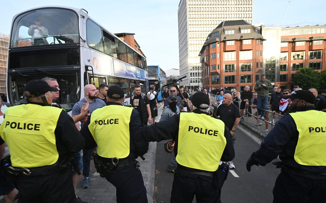 A protester threatens police officers with an electric scooter during the 'Enough is Enough' demonstration called by far-right activists in Bristol on 3 August, 2024. Far-right protesters clashed with British police during tense rallies as unrest linked to disinformation about a mass stabbing that killed three young girls spread across the UK.