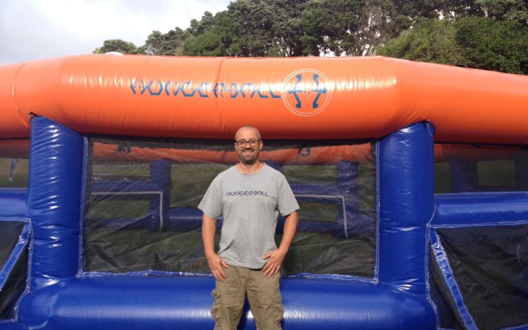 Andu Lordache stands in front of an inflatable Hungerball arena. He is looking proudly into the camera.