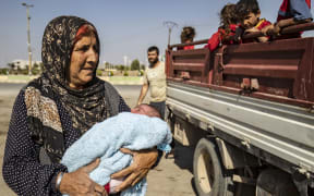 Syrian Arab and Kurdish civilians arrive to Tall Tamr town, in the Syrian northwestern Hasakeh province, after fleeing Turkish bombardment on the northeastern towns along the Turkish border on October 10, 2019.