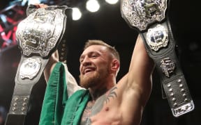 Conor McGregor with his two UFC belts.