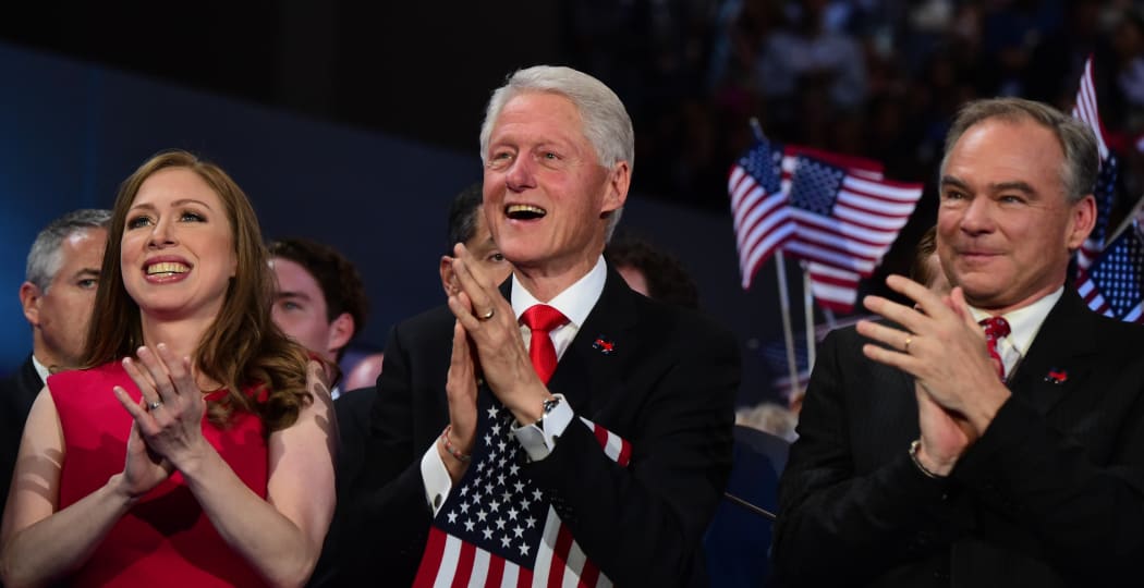 Chelsea Clinton, Bill Clinton and Democratic vice presidential candidate Tim Kaine applaud Mrs Clinton's speech.