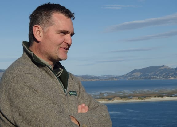 Lyndon Perriman standing in front of harbour view.