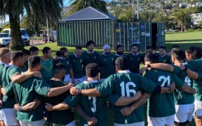 The Cook Islands men's rugby team huddle together before kickoff.