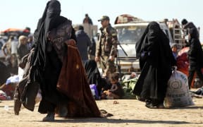 Civilians flee fighting between Syrian Democratic Forces (SDF) and Islamic State (IS) jihadists in the frontline Syrian village of Baghuz.