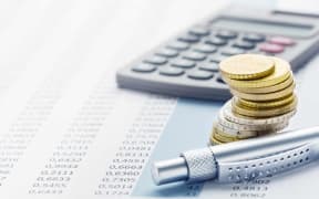 Finance - coins, calculator and table of figures.