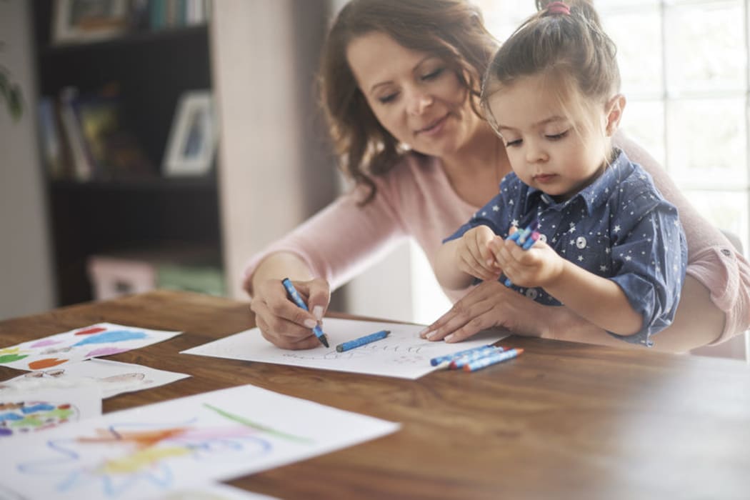 A photo of a mother helping her child with homework