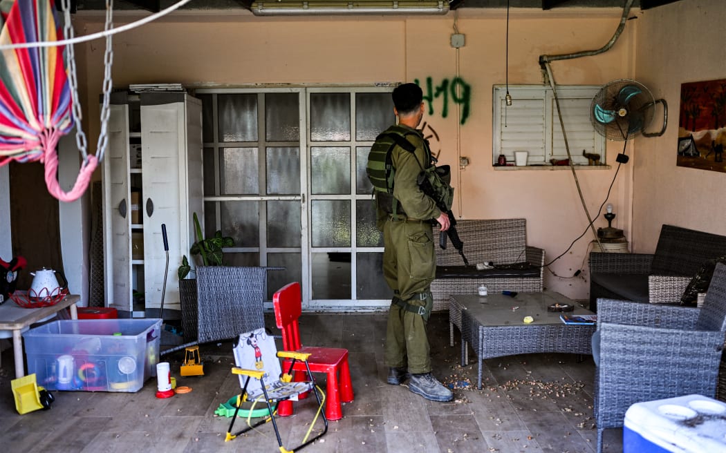 An Israeli soldier walks in one of the houses attacked by Palestinian militants on 7 October, while visiting there with a team of forensic experts, in Kibbutz Holit in Israel's southern district south of the Gaza Strip on October 26, 2023.