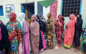 Internally displaced women wait in a queue to collect aid from a group at a camp in Gadaref on May 12, 2024. Clashes reignited between the Sudanese army and rival paramilitaries earlier this week in the key Darfur town of El-Fasher, the United Nations said May 12, killing at least 27 people in one day. (Photo by AFP)