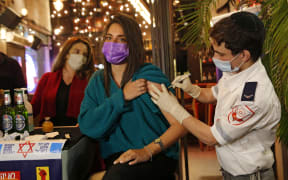 An Israeli health worker gives the Covid-19 vaccine at a bar in the coastal city of Tel Aviv on February 18