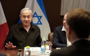 Israeli Prime Minister Benjamin Netanyahu, left, gestures during a meeting with French President Emmanuel Macron, back to camera, in Jerusalem on October 24, 2023.