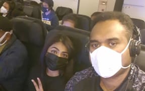 Fijian students Joe Racaca, right, and Sylvia Nandani aboard the chartered Air New Zealand flight from Wuhan.