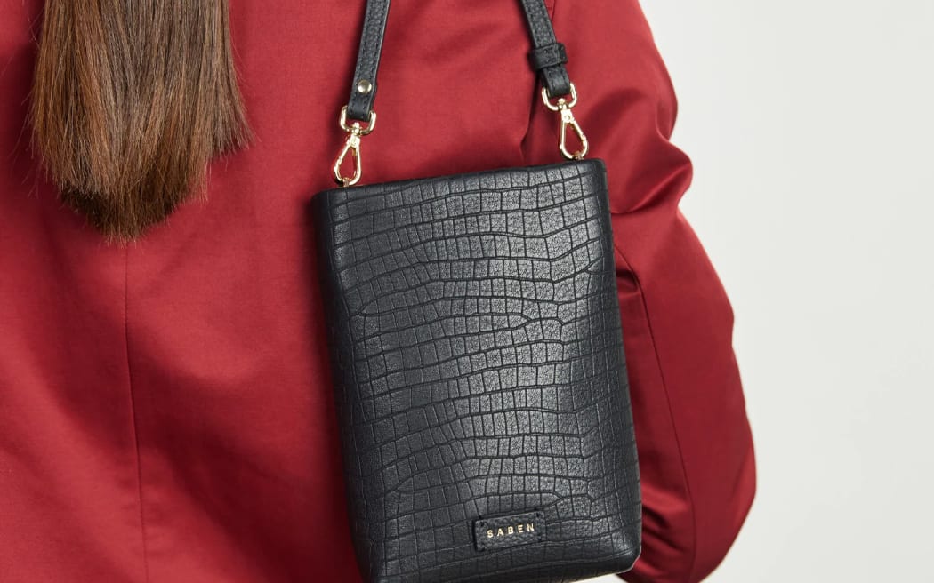 A woman carries a Saben bag over her shoulder.