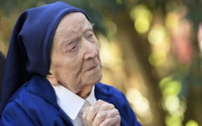 (FILES) In this file photo taken on February 10, 2021, Sister Andre, Lucile Randon in the registry of birth, the eldest French and European citizen, prays in a wheelchair, on the eve of her 117th birthday, in an EHPAD (Housing Establishment for Dependant Elderly People) in Toulon, southern France, where she has been living since 2009. - The world's oldest known person, Lucile Randon, known as Sister Andre, has died aged 118, her spokesman said on January 17, 2023. Randon was born in southern France on February 11, 1904, when World War I was still a decade away. (Photo by NICOLAS TUCAT / AFP)