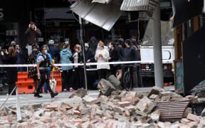 Residents gather near a damaged building in the popular shopping Chapel Street in Melbourne on September 22, 2021, after a 5.8-magnitude earthquake.