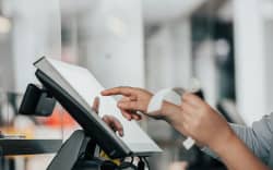 Someone holding a receipt and typing into a computer.