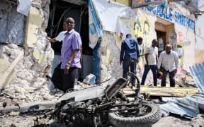 People clear debris in front of the destroyed Hayat Hotel after a deadly 30-hour siege by Al-Shabaab jihadists in Mogadishu, Somalia.