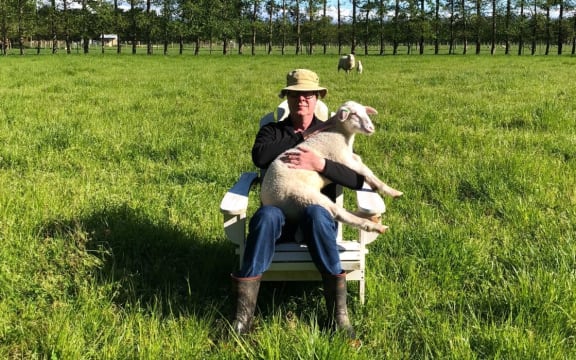 Journalist Greg Dixon with one of his lambs